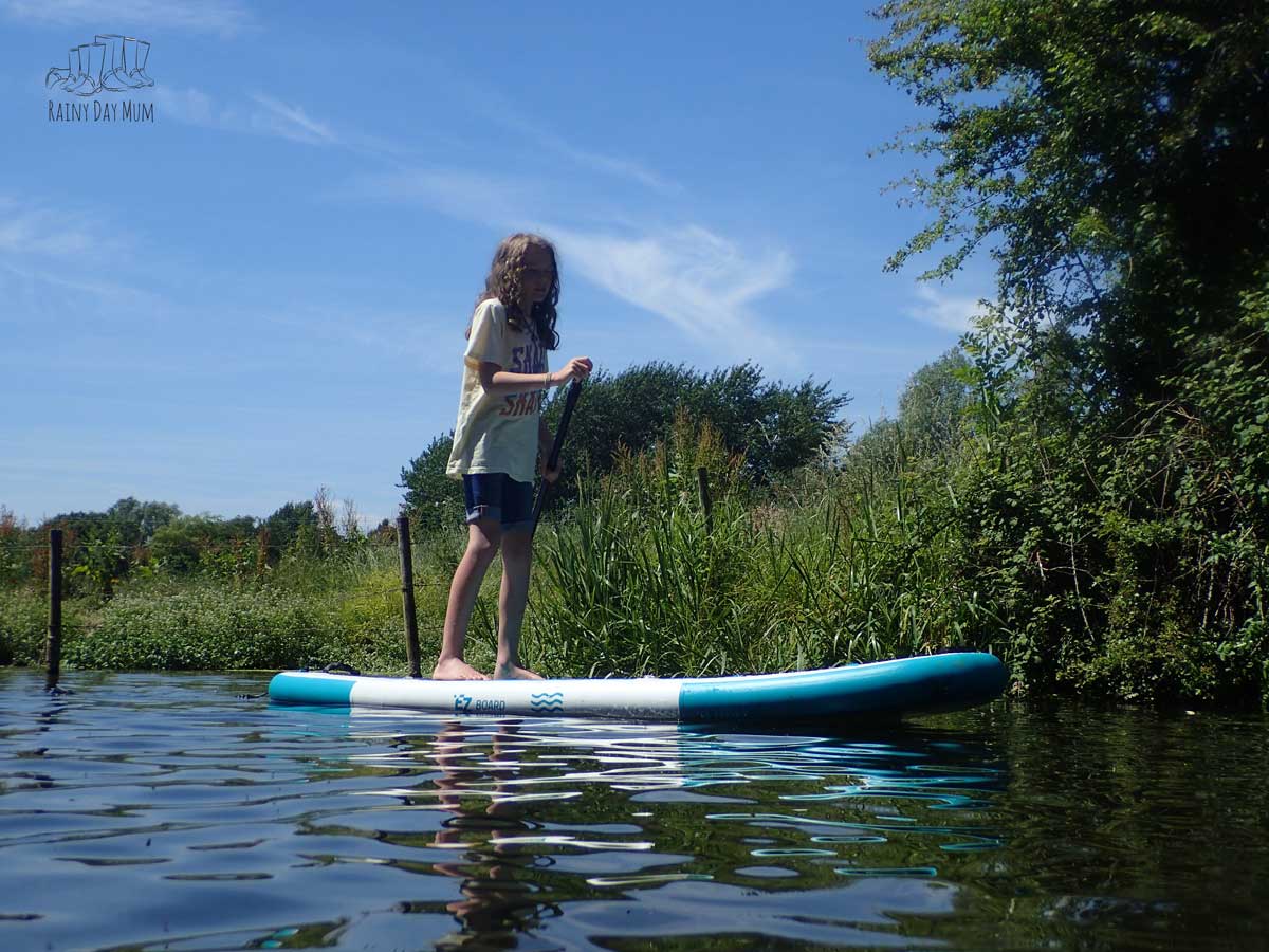 A tween paddleing on a SUP on a river in the UK.